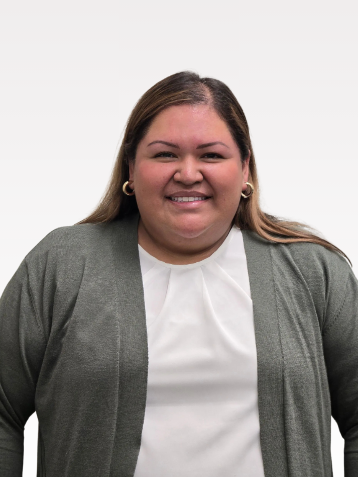 A woman wearing a green cardigan and a white shirt is smiling for the camera.
