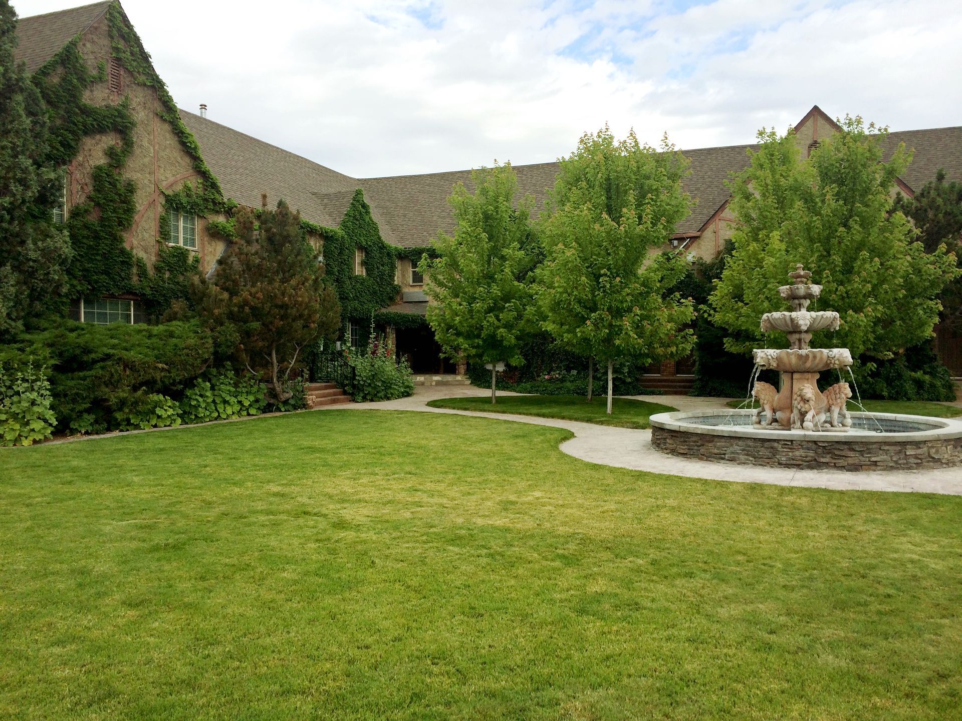 A large house with a fountain in front of it