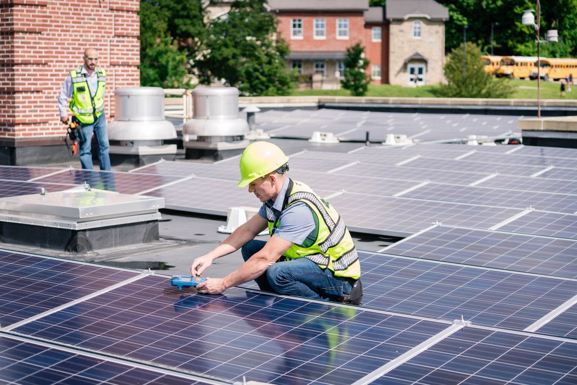 A man is installing solar panels on the roof of a building.