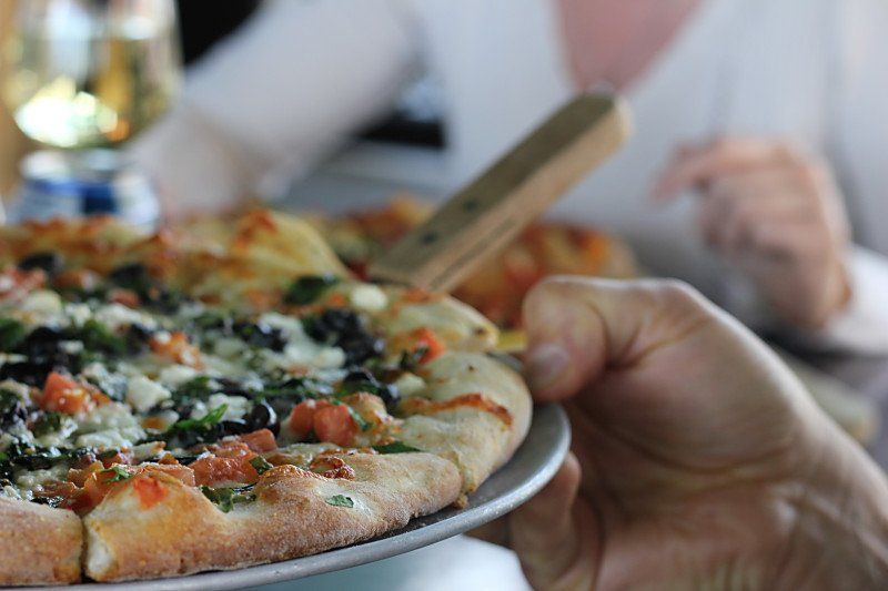 Una persona tiene in mano una pizza